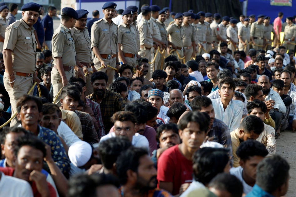 Des policiers indiens surveillaient des ressortissants bangladais présumés en situation irrégulière, arrêtés lors de descentes de police effectuées à Ahmedabad, ville située dans l'État du Gujarat, dans le nord-ouest de l'Inde. le 26 avril 2025. 