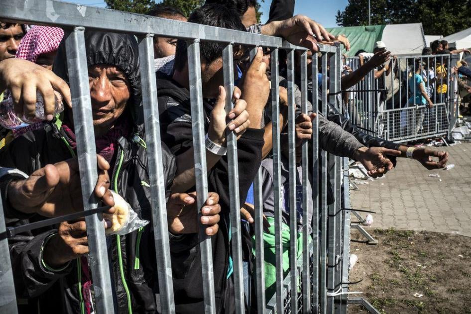 Asylum seekers behind a metal fence in the ‘Hangar 1’ detention center, in Röszke, Hungary.