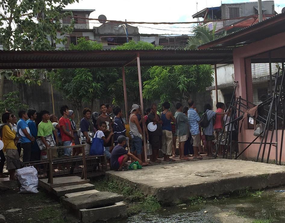 Some of those arrested and detained at the Jose Fabella Center in Manila line up for lunch on November 13, 2015. 