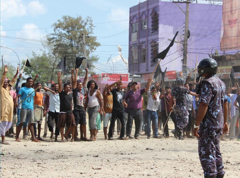A police officer faces protesters