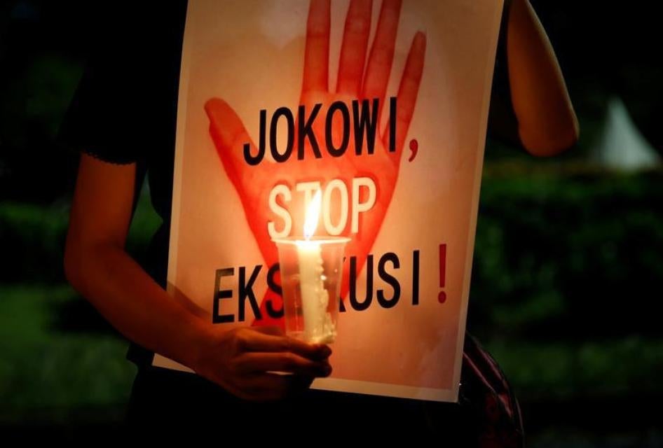 A protester holds a placard reading "Jokowi, stop executions" during a demonstration against Indonesia's decision to execute 14 drug convicts in front of the Presidential Palace in Jakarta, Indonesia, July 28, 2016.
