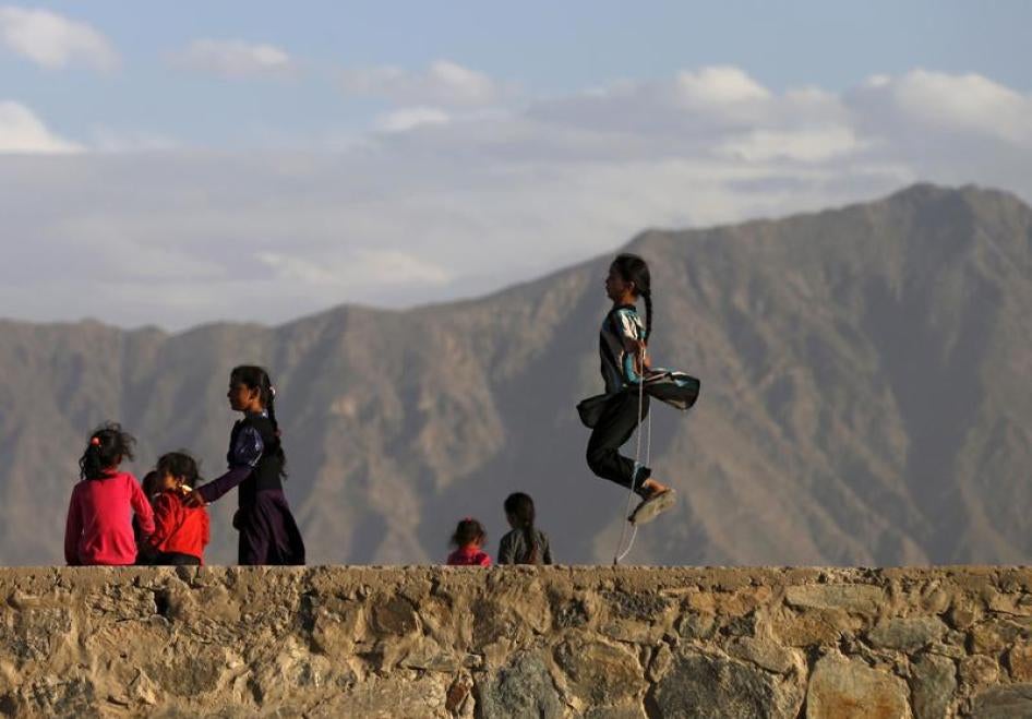 An Afghan girl (R) jumps rope on a hilltop in Kabul, Afghanistan May 18, 2015.