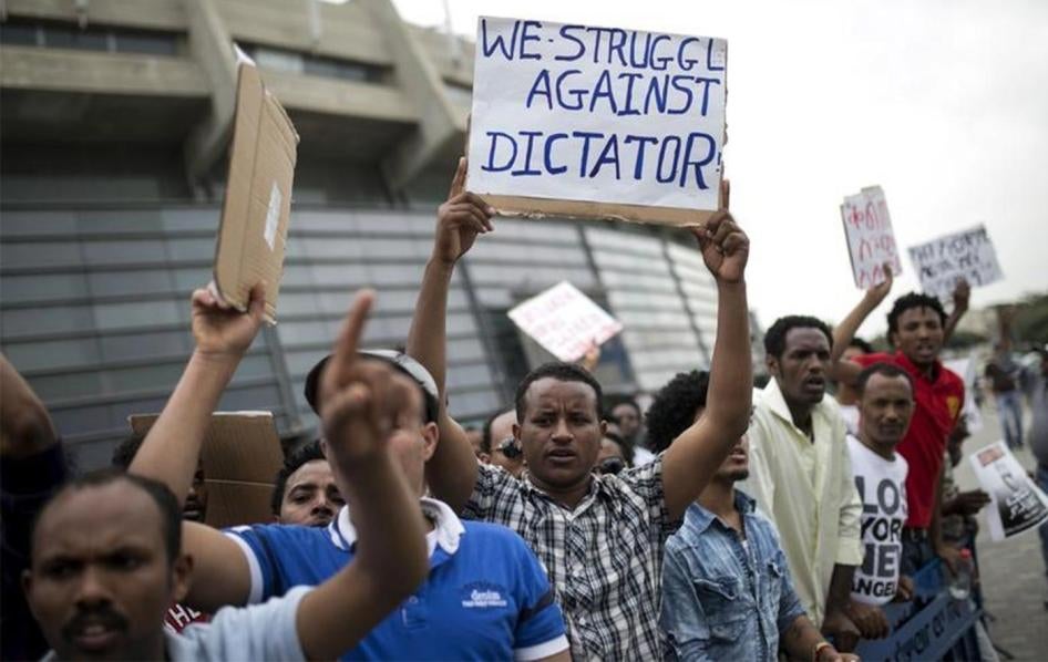 Eritrean refugees hold placards during a protest against the Eritrean government outside their embassy in Tel Aviv, Israel May 11, 2015.