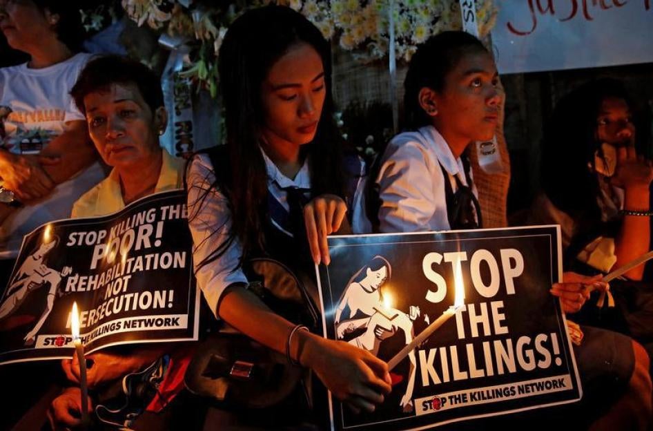 Protesters and residents hold lighted candles and placards at the wake of Kian Loyd delos Santos, a 17-year-old high school student, who was among the people shot dead last week in an escalation of President Rodrigo Duterte's war on drugs in Caloocan city
