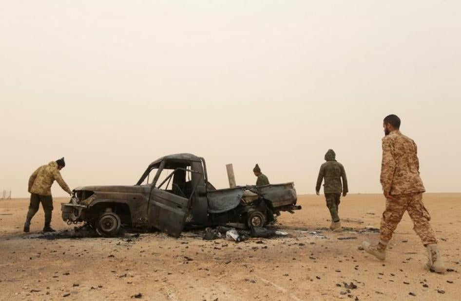 Members of Libyan National Army (LNA) inspect a damaged military vehicle after clashes with fighters from Benghazi Defense Brigades (BDB) in Ras Lanuf, Libya, March 16, 2017. 