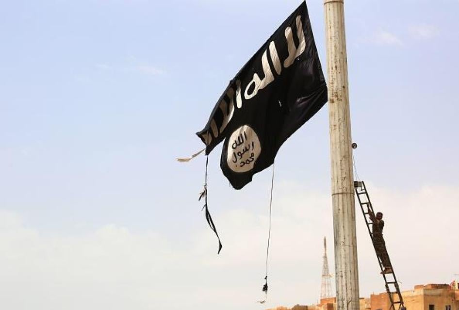 Un&nbsp;combattant des Forces démocratiques syriennes&nbsp;s'apprête à retirer&nbsp;un drapeau noir&nbsp;de l'État islamique&nbsp;dans la ville de&nbsp;Tabqa, à l'ouest de Raqqa en Syrie, le 30 avril 2017.