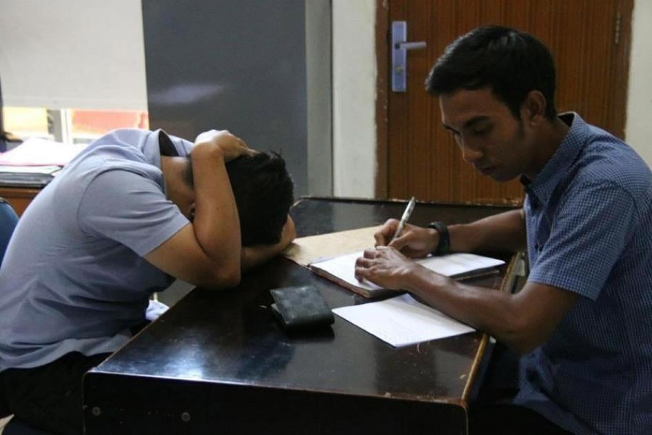 On March 29, 2018, vigilantes forcibly entered a private house in Aceh province and called the Sharia (Islamic law) police, who arrested two male college students for allegedly having sex. A police officer questions one of the men in the Sharia