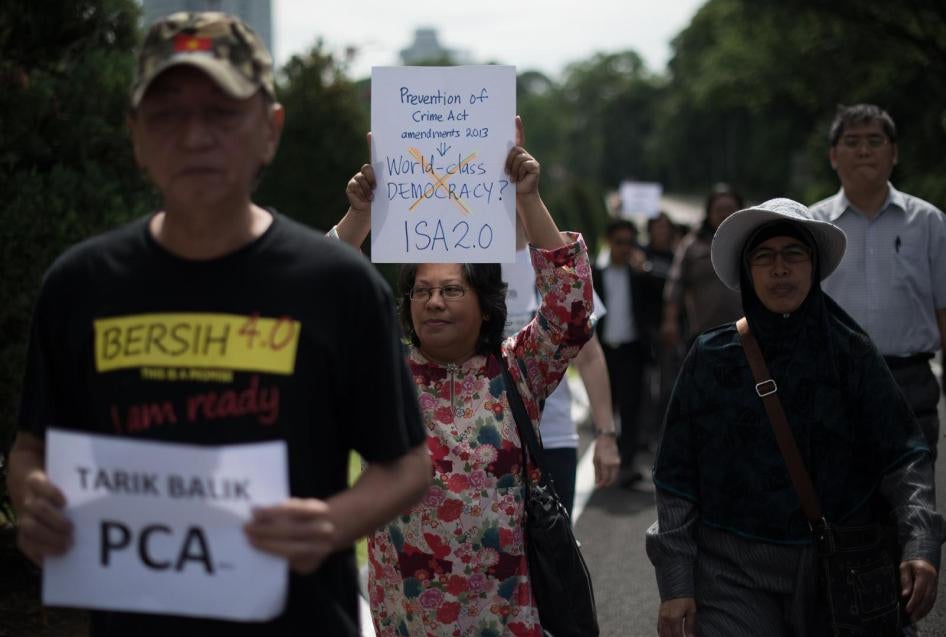 Activists hold placards during a protest against an amendment to a 1959 crime prevention act that would give police a stronger hand, outside the parliament house in Kuala Lumpur on September 30, 2013.