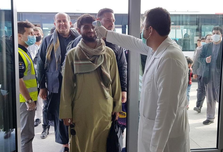 A medical officer scans a passenger for signs of fever at a bus station as a precaution against the coronavirus in Kabul, Afghanistan, March 27, 2020. © 2020 Sayed Khodaiberdi Sadat/Anadolu Agency via Getty Images