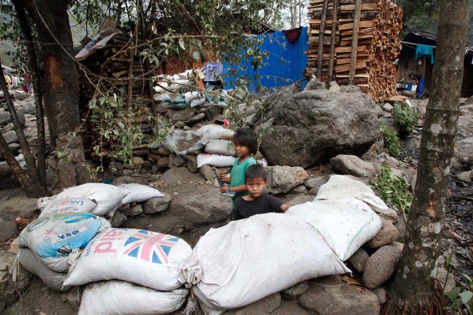 Children play in a makeshift bomb-shelter made with sandbags at Woi Chyai IDP camp, Kachin State, Myanmar.