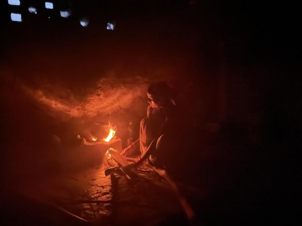 Wife of deceased migrant worker in the family kitchen.