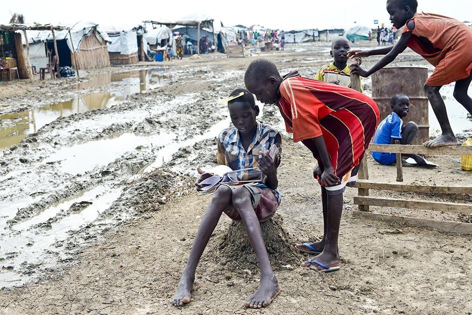 Schoolboys flipping through a notebook outside a classroom in the UNMISS camp near Bentiu in June. 