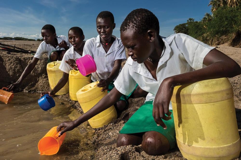 Girls from the Kalokol Girls Primary School fetch water from a dry riverbed to carry back to their school, which does not have access to running water. 