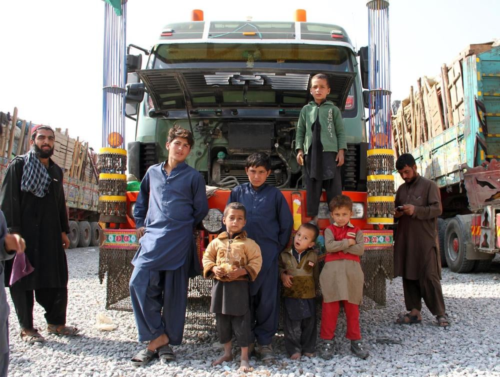 An Afghan refugee family forced out of Pakistan stands by a hired truck laden with their possessions after an overnight journey, October 2016