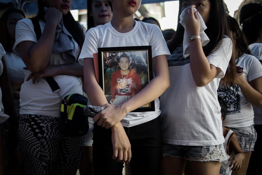 The sister of Jefferson Bunuan carrying his photo as they prepare to take his body to Manilla South Cemetery. August 1, 2016.