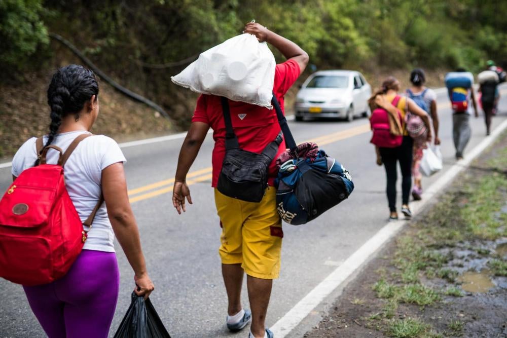 A group Venezuelan “caminantes” (“walkers”) carry their belongings after leaving the border city of Cucuta, Colombia on July 29, 2018. Every day, hundreds of Venezuelans begin the journey on foot towards other cities in Colombia, Ecuador, and Peru, lookin