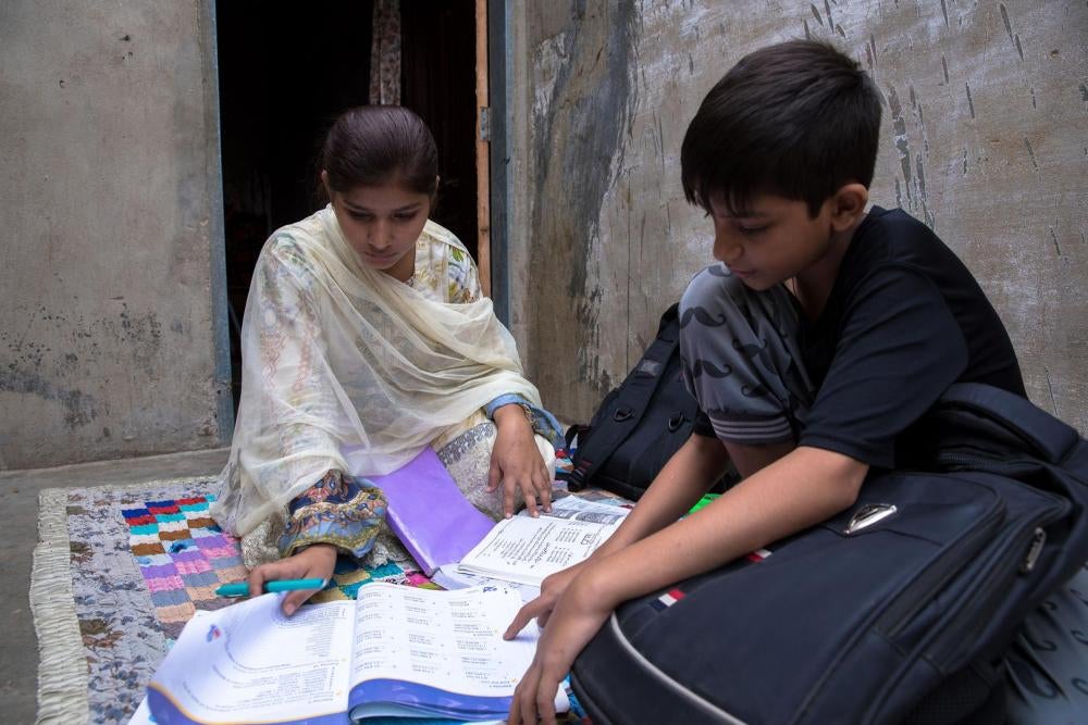 Bushra et son petit frère font leurs devoirs, assis sur le toit de la maison. Son frère fréquente un collège privé, avec des cours dispensés en anglais, tandis que Bushra va dans un lycée public, où l’enseignement est en ourdou. La mère de Bushra a déclar