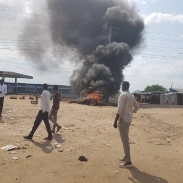 Civilians walk past burning tires during a protest in Shirkat, Juba, South Sudan on June 3, 2020. 