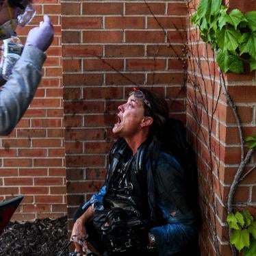 A protestor pours water over the face of woman who was injured by tear gas
