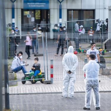 Members of a security service stand in protective gear inside a reception center for asylum seekers in North Rhine-Westphalia where 70 people tested positive for the virus that causes Covid-19, May 17, 2020. 