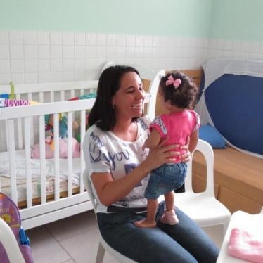 Uma mãe com sua filha adotiva de 3 anos que tem deficiência de desenvolvimento.