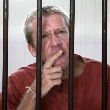 Michael Bryan Smith of England talks to reporters from the detention room at the criminal court in Bangkok, on Thursday, Feb. 18, 2010.