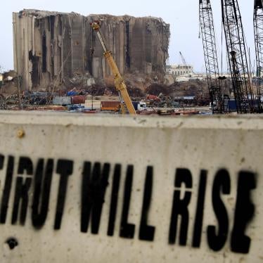 A slogan painted on a barrier in front of towering grain silos gutted in the massive August 2020 explosion at the Beirut port that claimed the lives of more than 200 people, December 2, 2020.