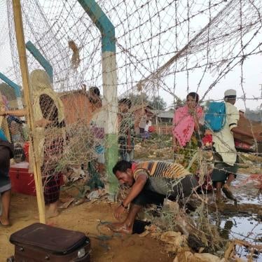 A man climbs through barbed wire fencing at a Rohingya refugee camp in Cox’s Bazar, Bangladesh, as a massive fire swept through the camps on March 22, 2021.