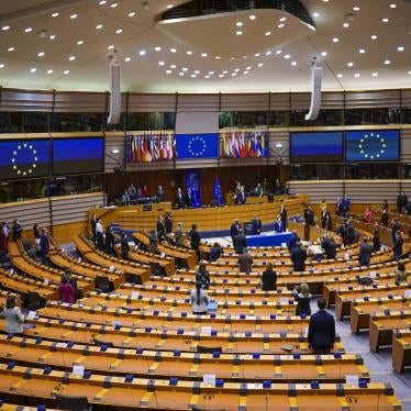 European lawmakers stand up during a signing ceremony at the European Parliament, Brussels, Belgium, March 10, 2021. 