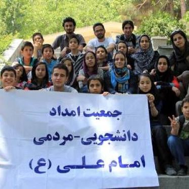 Members of the "Imam Ali Association" hold a banner with the association's logo and name.