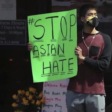 A man holds a sign reading “#StopAsianHate” outside Youngs Asian Massage in Acworth, Georgia on March 17, 2021, where four people were fatally shot the day before. 
