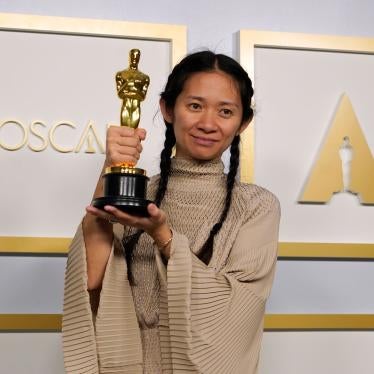 Director Chloe Zhao smiles and holds her golden Oscars statue after winning the award for Best Director