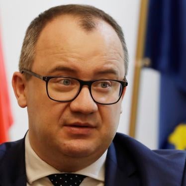 Adam Bodnar, the outgoing Human Rights Commission for Poland, speaks to The Associated Press from his office in Warsaw, Poland, standing in front of the Polish and EU flags.