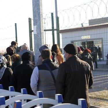 People wait outside a courthouse before the trial of 475 defendants in Ankara, Turkey