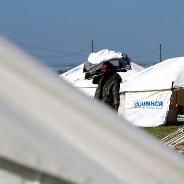 A migrant carrying a camp bed and bed clothes inside a refugee camp in Kokkinotrimithia outside of Nicosia, Cyprus, Tuesday, March 3, 2020.