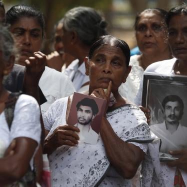 A group of women holding black-and-white photos of men