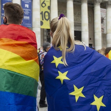 Demonstrators wrapped in LGBT and European Union flags are seen on August 30, 2020 in Warsaw, Poland. © 2020 Aleksander Kalka/NurPhoto via AP