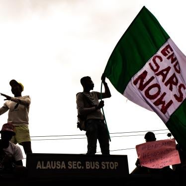 #EndSARS protesters hold up signs, including a Nigerian flag with a message calling for the disbandment of the abusive police unit, during protests on October 15, 2020 in Alausa Lagos, Nigeria. 
