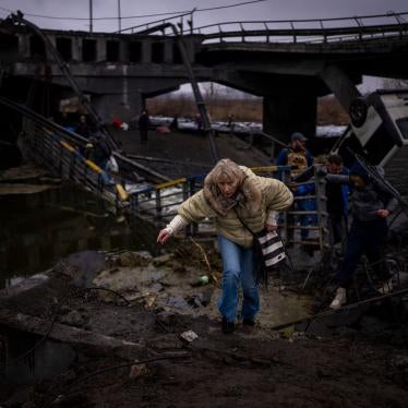 People flee across a destroyed bridge on the outskirts of Kyiv, Ukraine, March 2, 2022.