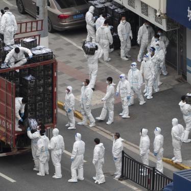 People in PPE load groceries off a truck before distributing them to locals under the Covid-19 lockdown in Shanghai, China, April 5, 2022.