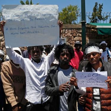 Migrants hold placards during an anti-racism demonstration