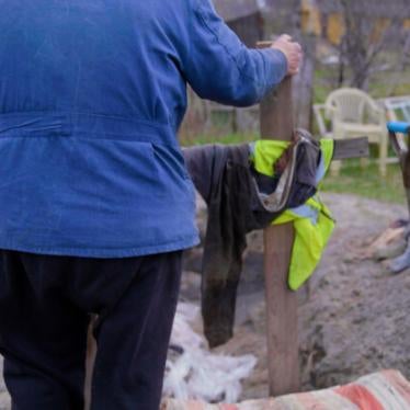 A man puts a cross on a burial site in Ukraine. 