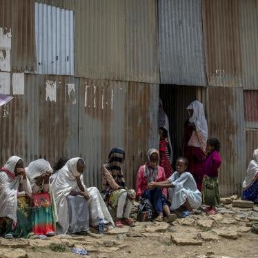 Displaced Tigrayans sit alongside metal shacks in Mekele, Ethiopia.