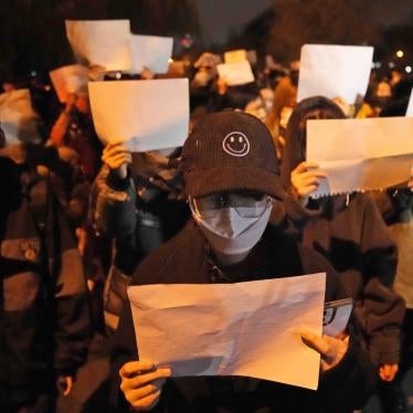 Protesters hold up blank papers and chant slogans as they march in protest in Beijing
