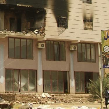 Men walk by a damaged building