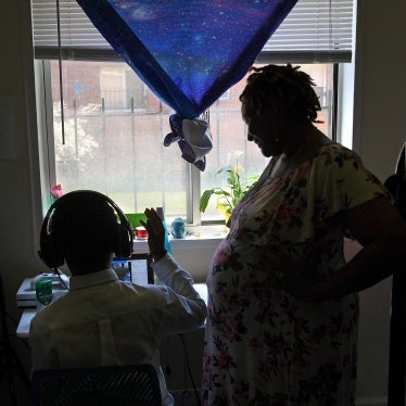 A pregnant woman checks in on her son in their apartment in Washington, DC. during the Covid-19 pandemic,  July 14, 2020.