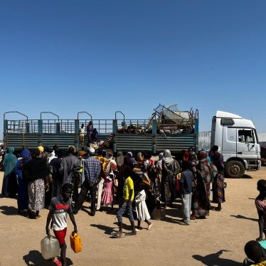 People get out of a truck that brought them from the border with Sudan to the transit center in Renk, South Sudan; just a few suitcases and bed railings can be seen.