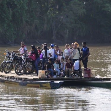 People cross a river to Venezuela from Tibu, Colombia on January 21, 2025, following fightings that killed dozens and forced thousands to flee their homes in the Colombian Catatumbo region.