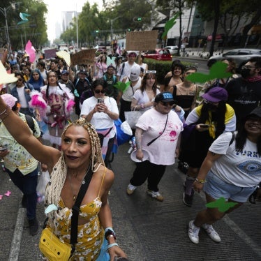 A demonstrator throws colored papers shaped like butterflies during a protest