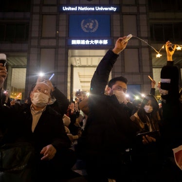 People protest outside a university building at night